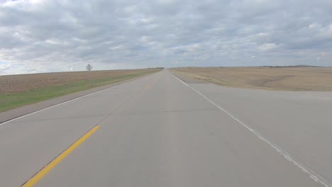 POV-driving-on-a-paved-rural-road-between-harvested-fields-in-rural-south-central-Nebraska-on-a-cloudy-winter-day