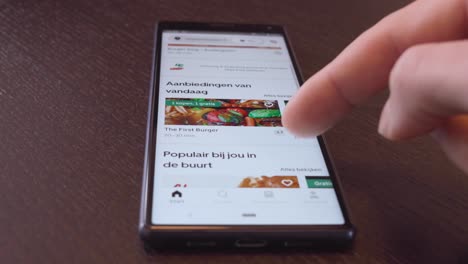 Finger-scrolling-through-restaurant-food-pictures-on-Uber-Eats-app-during-Corona-lockdown