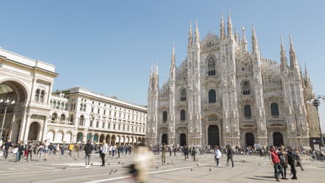 Timelapse-of-crowd-of-tourists-walking-around-Cathedral-Square-in-stunning-Duomo-di-Milano,-Milan-Cathedral-on-sunny-blue-sky-summer-day-in-Milan,-Lombardy,-Italy