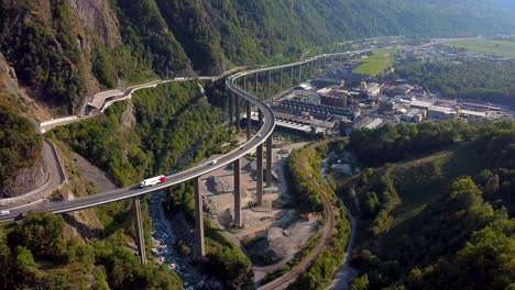 Aerial-locked-shot-of-an-industrial-area-and-huge-bridge-in-the-mountains