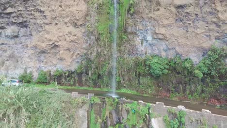 Car-waterfall-at-old-road-on-the-edge-of-a-rocky-cliff-in-"Anjos",-Ponta-do-Sol,-Madeira-island,-Portugal
