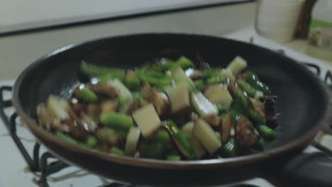 Shaking-vegetables-drizzled-in-olive-oil-on-a-hot-pan-over-the-stove