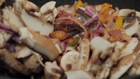Motion-controlled-slow-motion-shot-of-mushrooms-in-a-cooking-pan