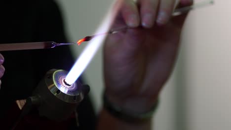 Close-Up-Of-Blowtorch-Flame-And-Hands-Holding-Elements-Being-Heated