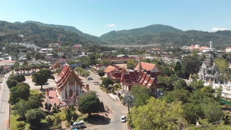 Wide-Panoramic-of-Wat-Chalong-temple-grounds-on-a-hot-sunny-day-in-Phuket,-Thailand---Aerial-low-angle-wide-Panoramic-shot