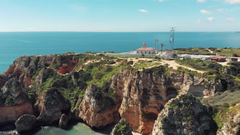 Leuchtturm-Ponta-Da-Piedade-über-Kalksteinlandspitze-In-Lagos,-Algarve,-Portugal---Luftfliege-Im-Breiten-überblick