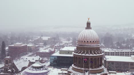 Orbiting-aerial-of-the-capital-building-in-Boise,-Idaho-with-a-layer-of-snow-on-it
