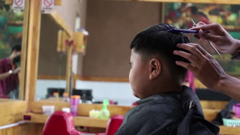 Asiatischer-Junge,-Der-Frisur-Im-Friseursalon-Bekommt