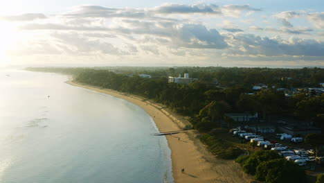 Aerial-Drone-Over-Coastal-Beach-Town-And-Sandy-Shore-At-Sunrise,-Australia-4K