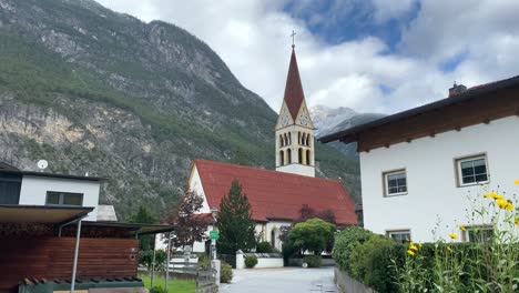 Church-in-Tyrol-Austria-showing-first-snow-on-mountain-behind