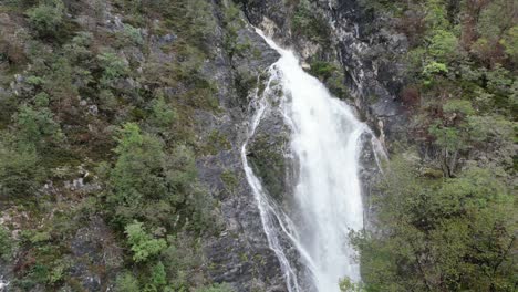 Push-In-Schuss-Wasserfall,-Der-Durch-Bäume-Kaskadiert-See-Bohinj-Slowenien-Drohne-Luftbild