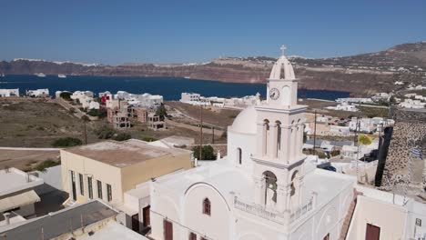 Aerial-close-fly-by-greek-church-bell-tower-at-Akrotiri-village-in-Santorini,-Greece