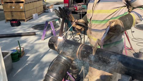 Close-up-shot-of-a-welder-welding-a-job-into-a-large-metal-pipe