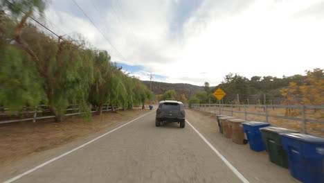 FPV-follow-shot-of-a-Rezvani-driving-and-braking-on-a-town-road-in-California