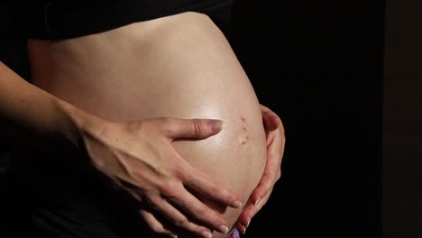 Schwangere-Frau-Hautpflege-Auf-Schwarzem-Hintergrund