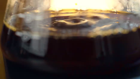 Aus-Dem-V60-Aufgebrühtes-Kaffeewasser-Tropft-In-Einen-Glasbehälter,-Zeitlupe-Und-Nahaufnahme