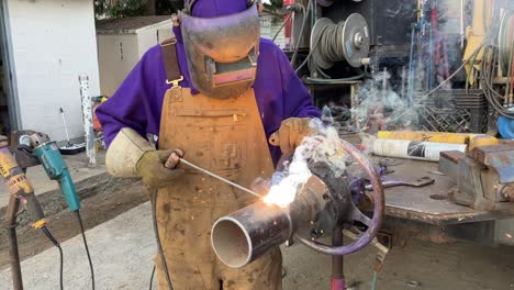 Close-up-shot-of-an-experienced-welder-welding-a-pipe-outside