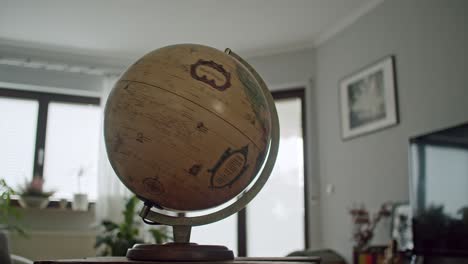 Schuss-Eines-Vintage-Globus,-Der-Sich-Schnell-In-Einem-Modernen-Wohnzimmer-Dreht