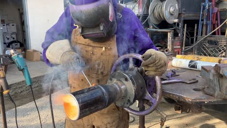 Rotating-shot-of-a-welder-welding-a-metal-pipe-together