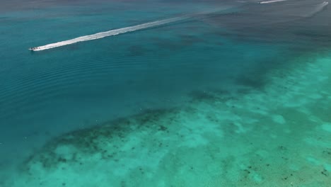 drone-shot-of-boat-speeding-at-Playa-Chen-Rio-in-Cozumel-island,-Mexico