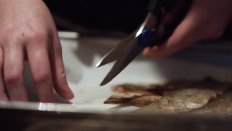 Chef-is-cutting-crispy-fish-skins-with-scissors