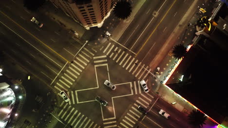 Aerial-shot-of-a-crossroad-with-cars-passing-through-the-junction