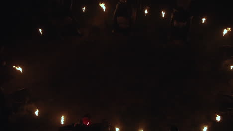 Panning-down-shot-revealing-a-circular-statue-monument-with-fire-torches