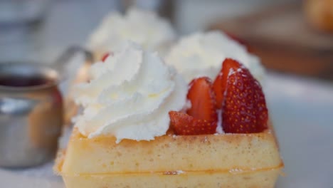 Close-up-of-waffles,-strawberries-and-whipped-cream