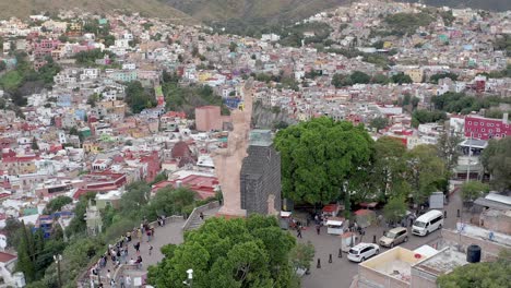 Aerial:-amazing-view-of-a-statue-of-a-Mexican-warrior-and-the-city-of-Guanajuato