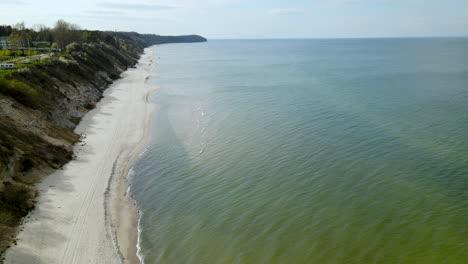 Beautiful-aerial-shot-along-white-sand-beach-on-Baltic-Sea-in-Poland