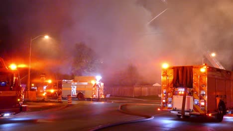 Group-of-fire-engine-trucks-at-fire-scene-with-massive-smoke,-handheld-view