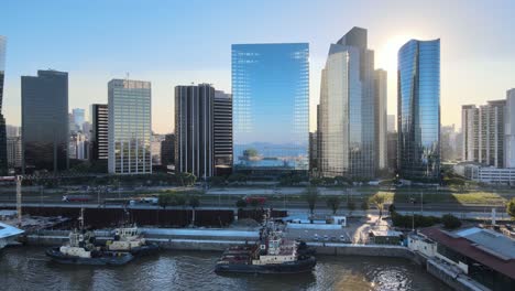 Aerial-dolly-in-of-boats-in-Puerto-Madero-docks-with-high-rise-skyscrapers-at-golden-hour,-Buenos-Aires