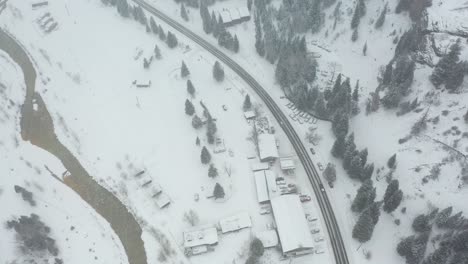 Drohnenaufnahme-Von-Oben-Nach-Unten-Des-Verschneiten-Straßenverkehrs-Im-Winter-Bei-Schneefall-Im-Malerischen-Tal-Im-Ländlichen-Colorado-USA,-Luftbild-Aus-Der-Vogelperspektive