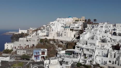 Dramatic-rotating-aerial-of-Santorini-architecture-and-cliff-top-view