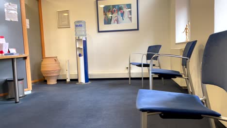 Leeres-Wartezimmer-In-Der-Arztpraxis-Mit-Stühlen,-Sodabrunnen-Und-Sonnenlicht