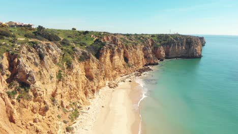 Canavial-Beach-framed-by-scenic-cliffs-in-Lagos,-Algarve,-Portugal---Aerial-Fly-over-Tracking-shot