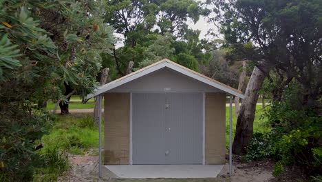 pull-out-shot-of-a-boat-shed-hut-in-amongst-trees