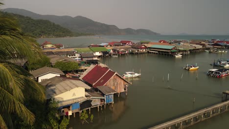 Fast-aerial-pan-to-the-right-of-the-Bang-Bao-fishing-pier-in-Koh-Chang,-Thailand