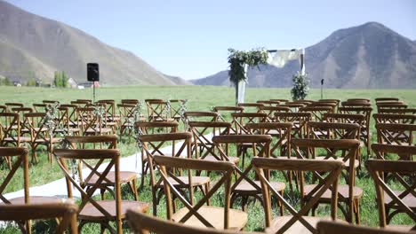 Outdoor-Wedding-Venue,-Seating-And-Floral-Arch-With-Mountain-Backdrop