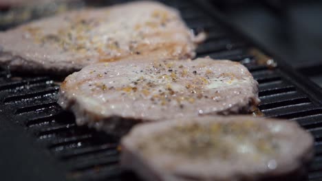 Cooked-Steaks-With-Steam-Rising-Off-Of-Them-On-A-Metal-Griddle,-Slow-Motion-Static-Shot