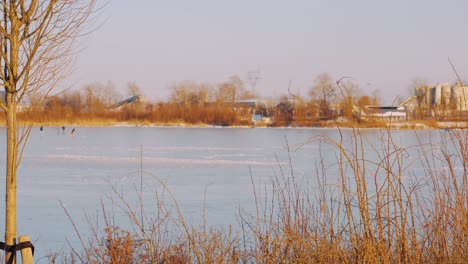 People-skating-on-a-frozen-lake-in-Radio-Kootwijk,-Netherlands,-wide-shot