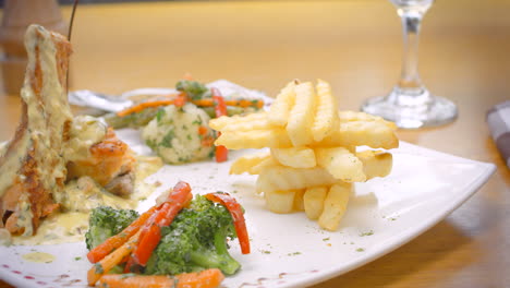 Salmon-in-white-sauce,-French-fries-and-steamed-vegetables,-Mediterranean