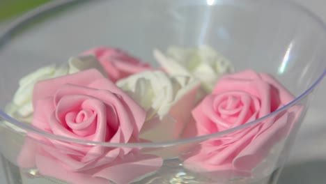 Pink-carnation-flowers-roses-floating-in-water-in-clear-bowl