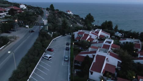 Drohne-Geschossen-über-Häuser-Die-Straße-Und-Den-Strand-Am-Abend-In-Griechenland