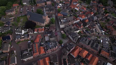 Rop-down-aerial-rotating-movement-showing-historic-Dutch-city-Groenlo-with-church-tower-rising-above-the-authentic-medieval-rooftops