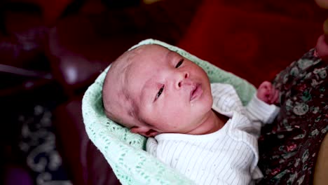 Neugeborenes-Baby-Mit-Rasiertem-Kopf,-Das-Sanft-In-Den-Armen-Der-Mutter-Geschaukelt-Wird