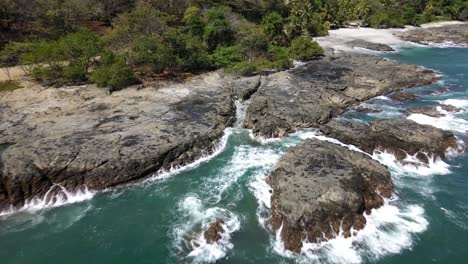 Costa-Rica,-Rocky-Stone-Coast-with-waves-splashing-aginst-the-stones,-Drone-Shot