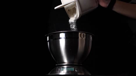 Person-pouring-flour-in-bowl-on-digital-scale