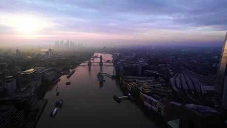 Atemberaubende-Londoner-Skyline-Aus-Der-Luft-Mit-Lila-Rosa-Sonnenuntergangshimmeln-über-Der-Themse