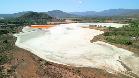 Aerial-images-of-a-dry-salt-flat-in-Sardinia-Italy-mountain-flamingos-in-the-background